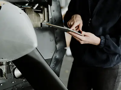 Technician on a tablet device performing an aircraft inspection